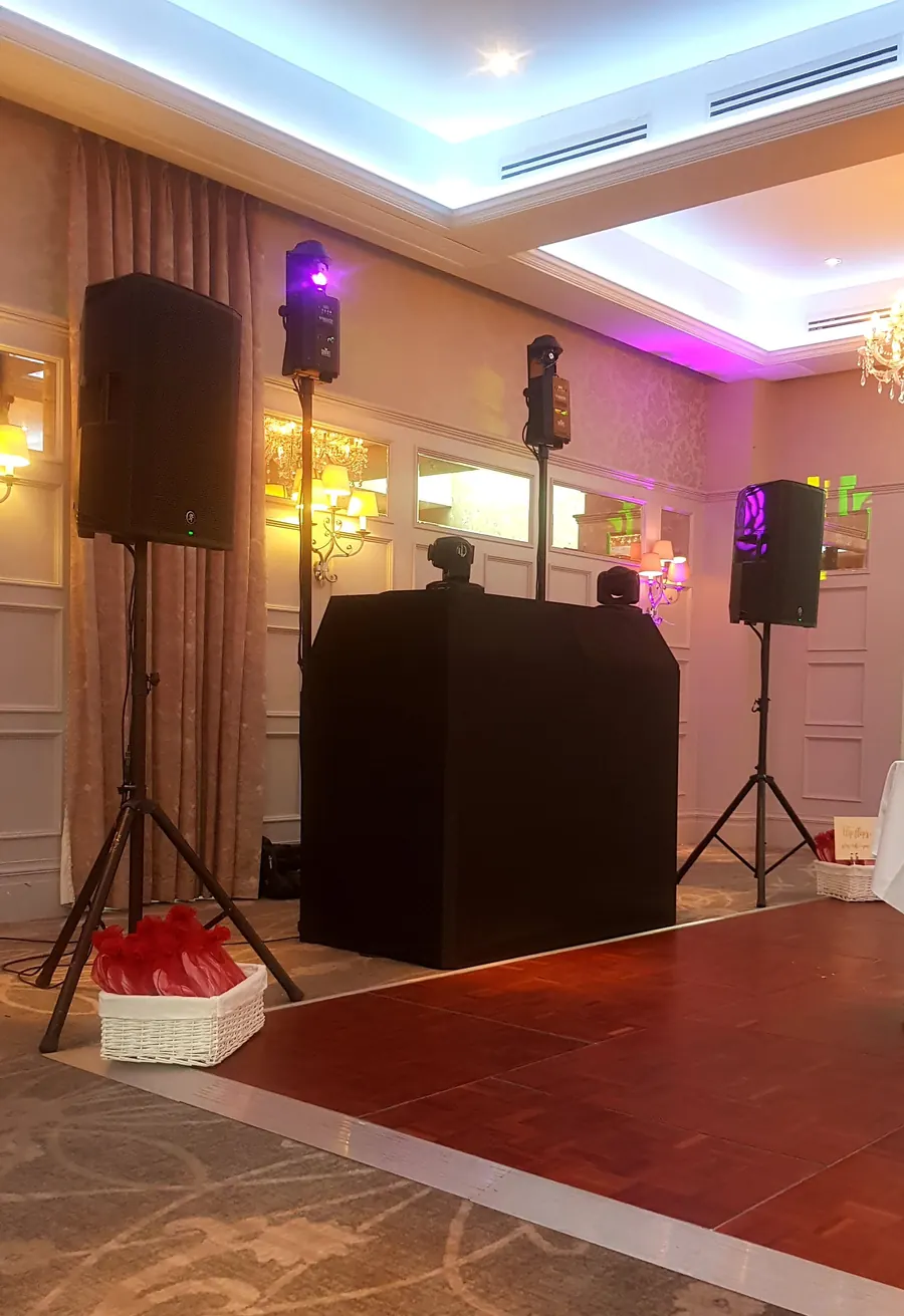 Choice DJ booth, speakers and moving-head lighting set up beside the dance floor in an elegant function room